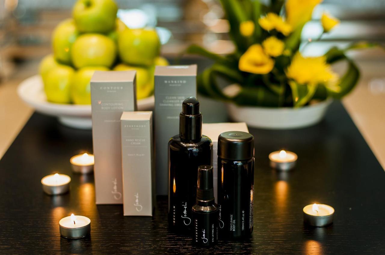 Dubai International Terminal Hotel Exterior photo The photo features several skincare or beauty product bottles arranged on a dark tabletop. There are three black bottles of varying sizes, likely containing serums or oils, alongside several light-colored boxes with a minimalist design, possibly for 